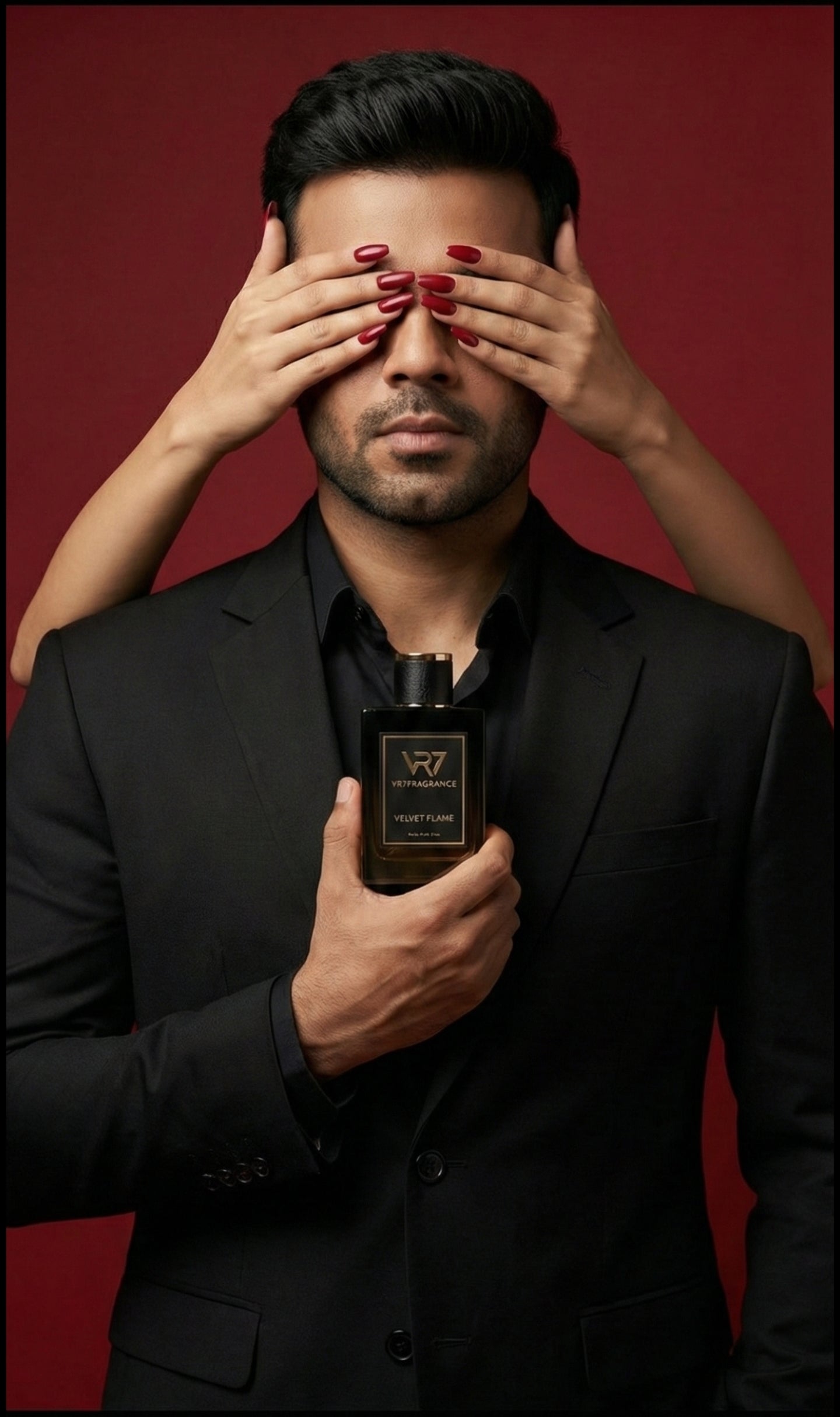 Man in black suit holding a bottle of vr7fragrance house against a red background